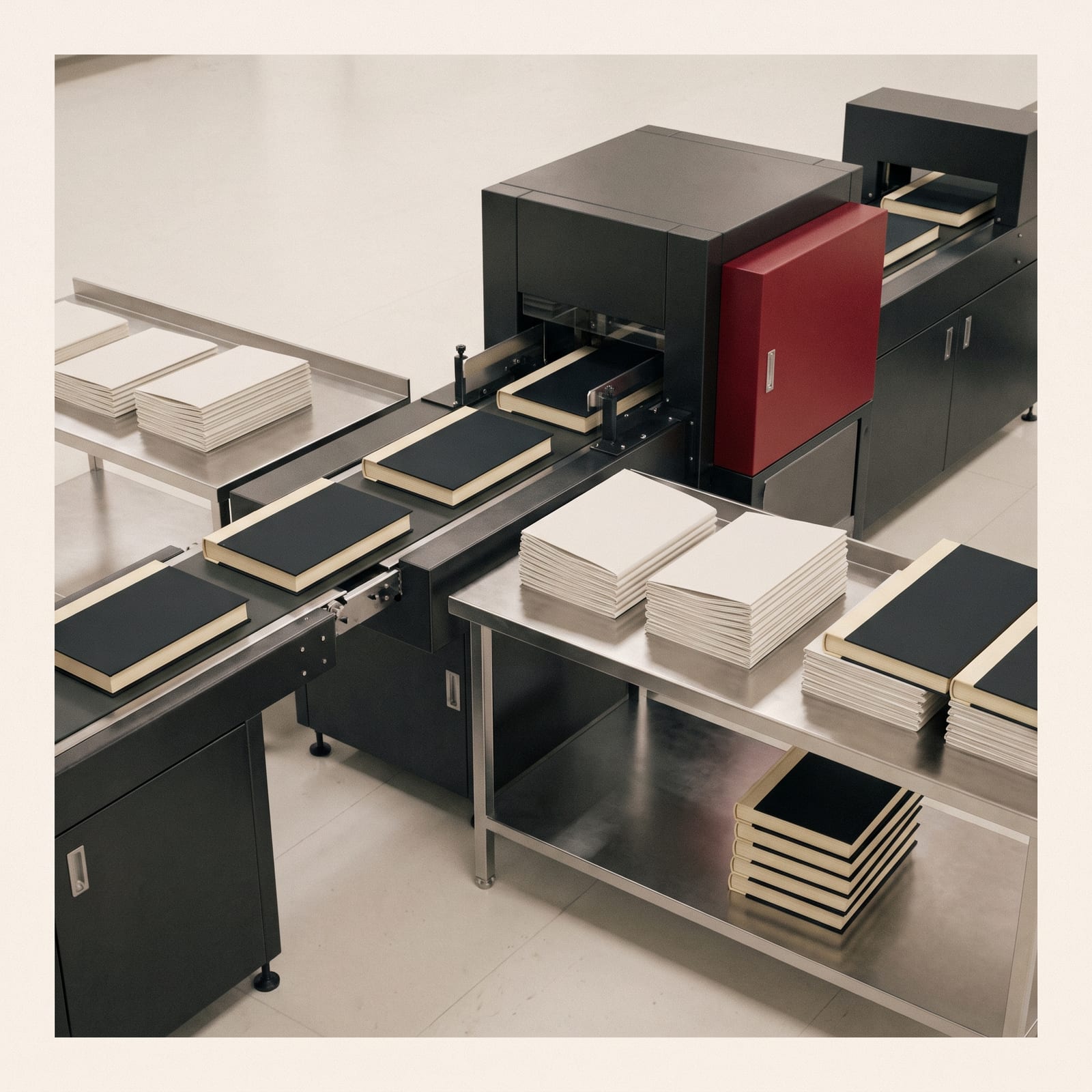 Hardcover book binding line at a Toronto bindery — freshly cased-in picture books stacked beside the casing-in machine